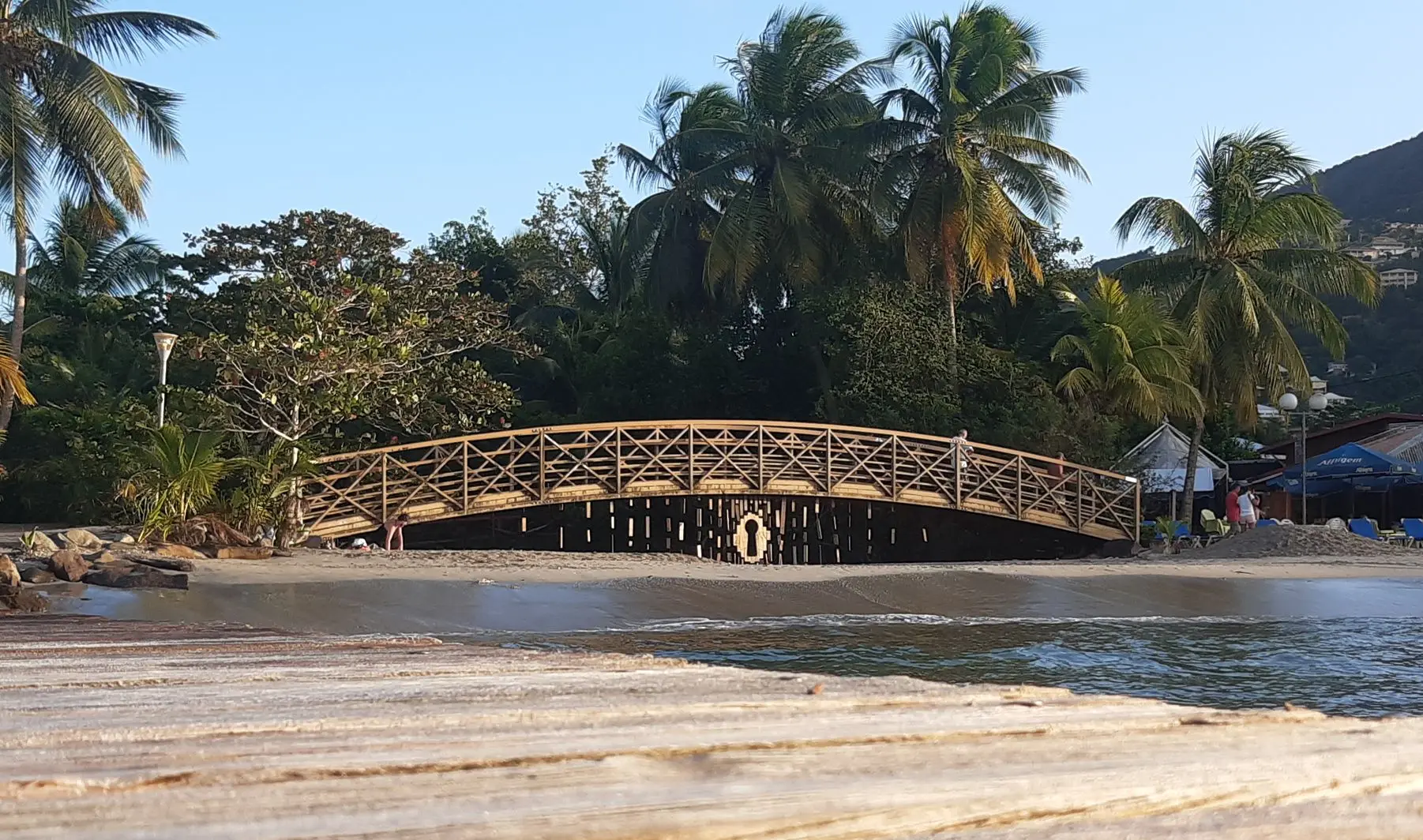 Installation artistique sous un pont devant la mer.